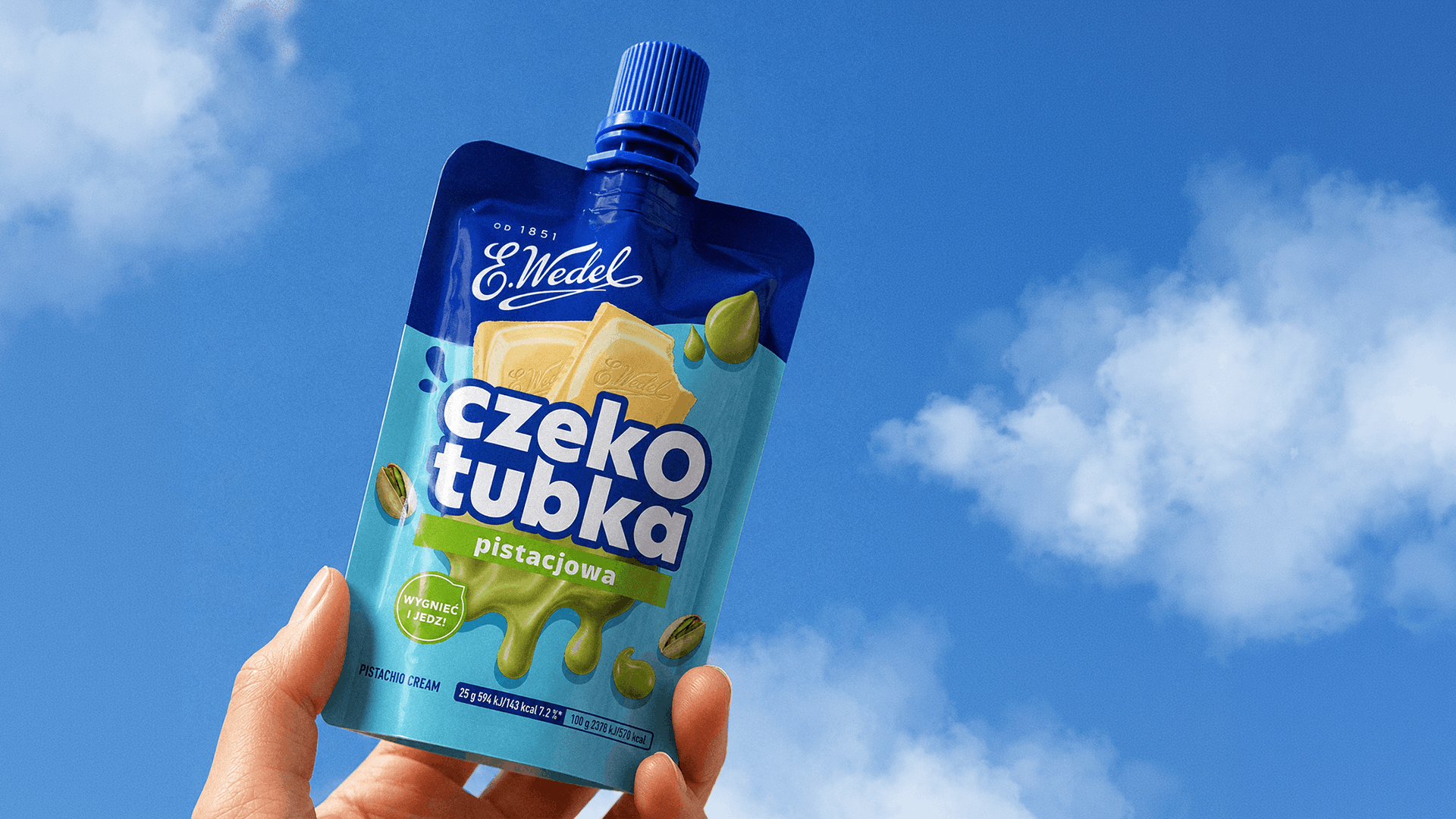 Czekotubka Pistacjowa E.Wedel trzymana na tle błękitnego nieba | packaging design FYNK Kraków