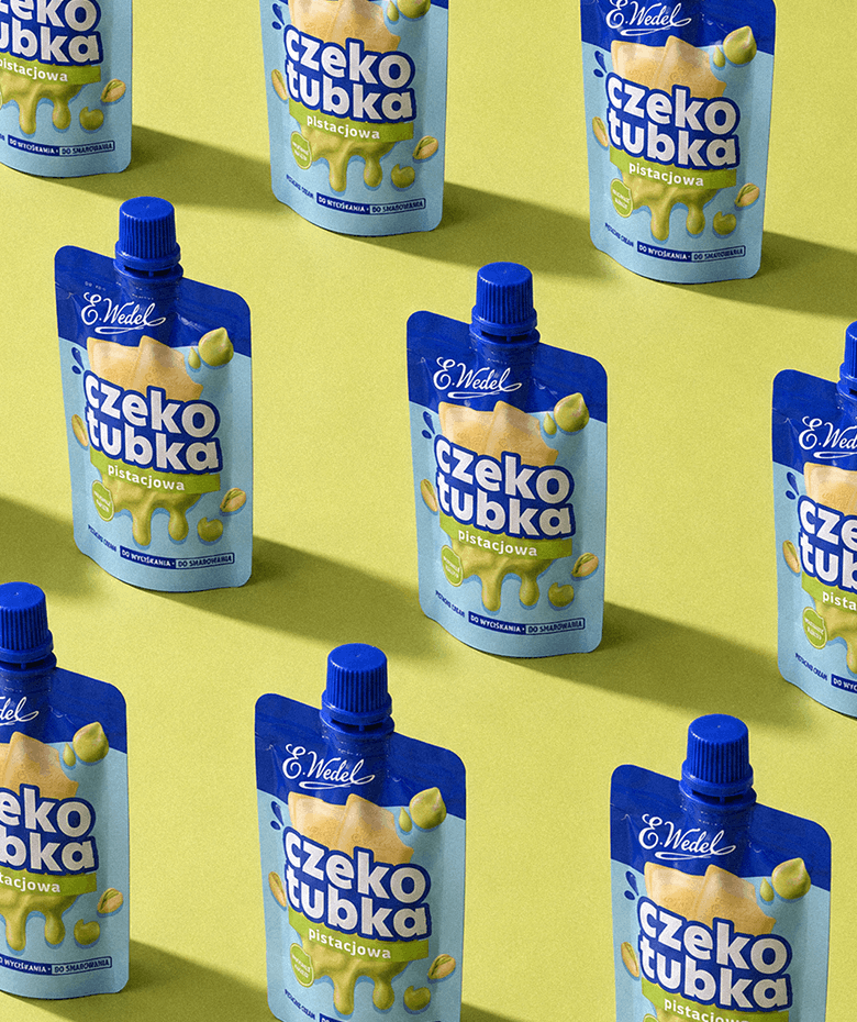 Czekotubka Pistacjowa E.Wedel trzymana na tle błękitnego nieba | packaging design FYNK Kraków